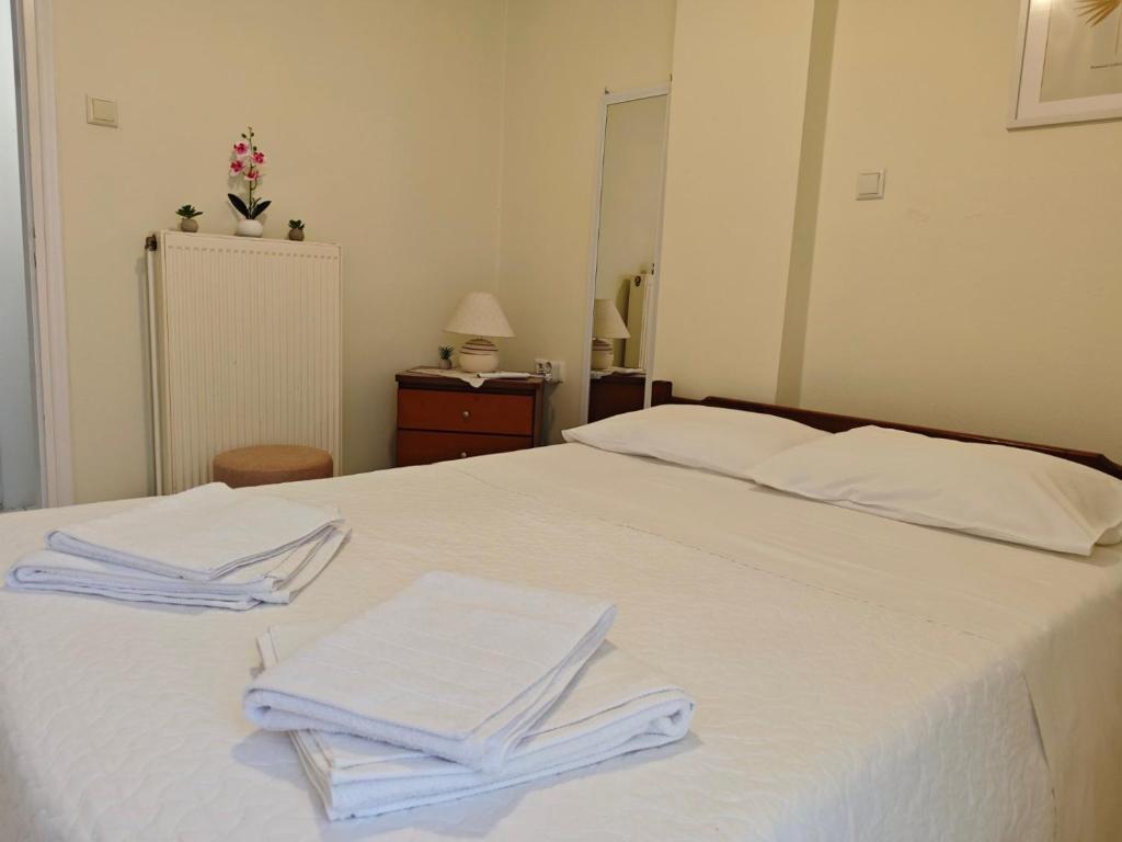a white bed with two towels on top of it at Mary's Home in Kalamata
