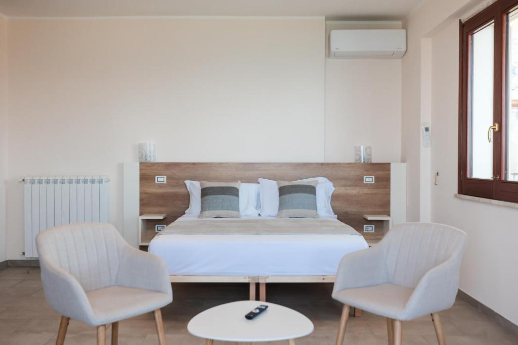 a bedroom with a bed and two chairs at La Rocca di PA in Tropea