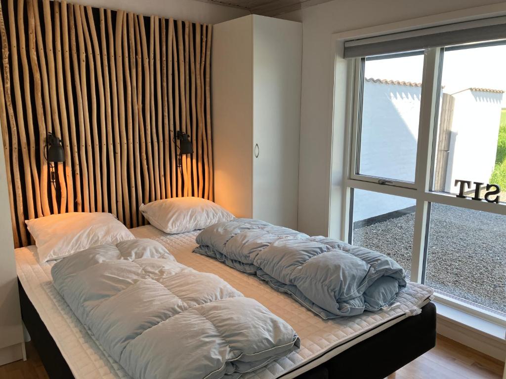 two beds sitting on a bed in a room with a window at Havrevang Lønstrup, Ferielejligheder in Lønstrup