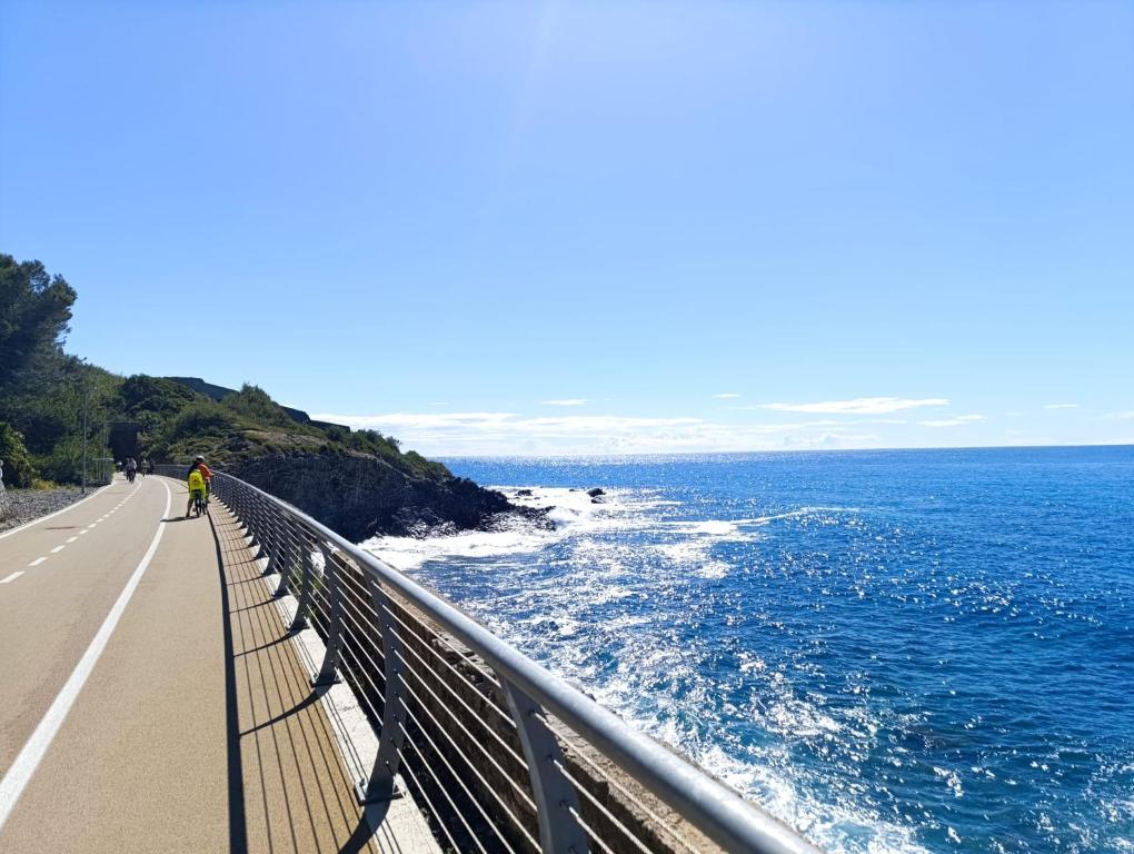 a person walking on a bridge over the ocean at Uliveto in Diano San Pietro