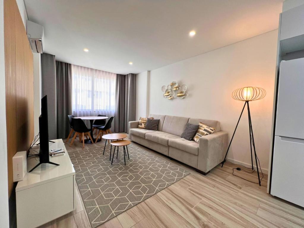 a living room with a couch and a table at Timeless Beach V - Apartment in Armação de Pêra