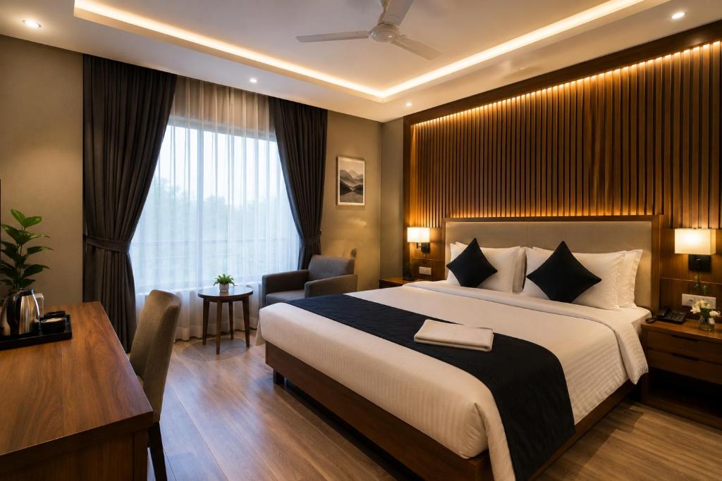 a hotel room with a large bed and a desk at Satya Avenue Dehradun, Near Pearl Paradise IT park Road in Dehradun