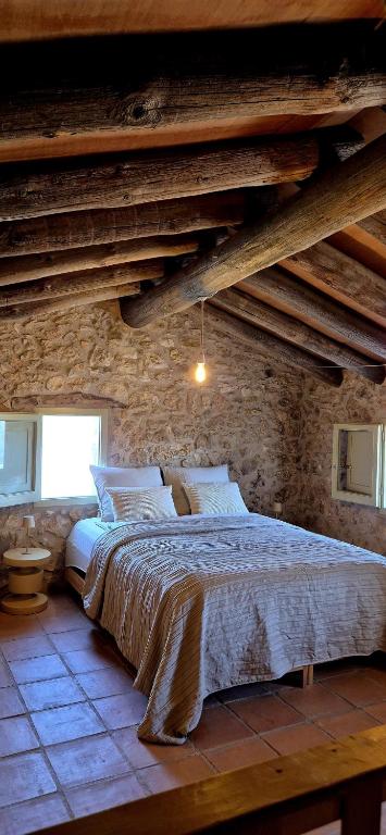 a bedroom with a large bed in a stone wall at Casa Utopia in Miravet