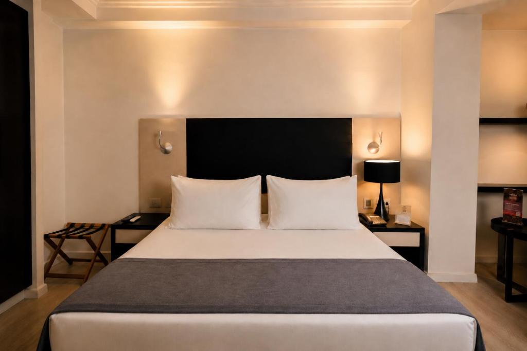 a bedroom with a large white bed with two pillows at Hotel Sommelier Agustinas in Santiago