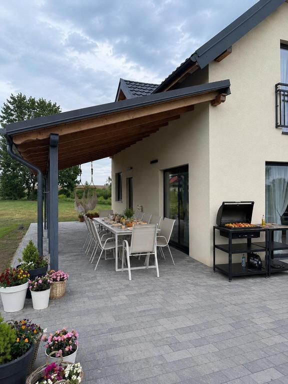 a covered patio with a table and chairs at Pod Skrzydłami II in Liksajny