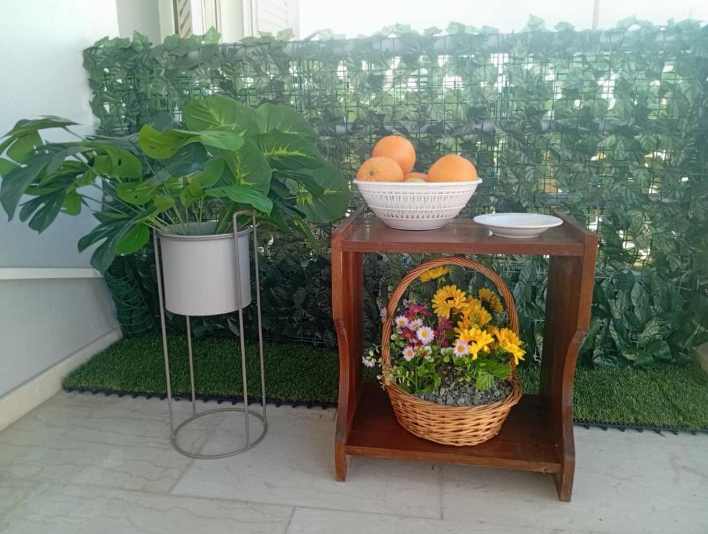 a table with flowers and oranges and a basket of oranges at on the STRIP-Studio 2 in Kavos
