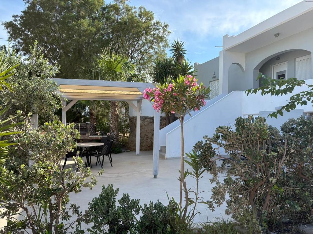 a patio with a table and chairs and trees at Villa Memories in Palaiochora