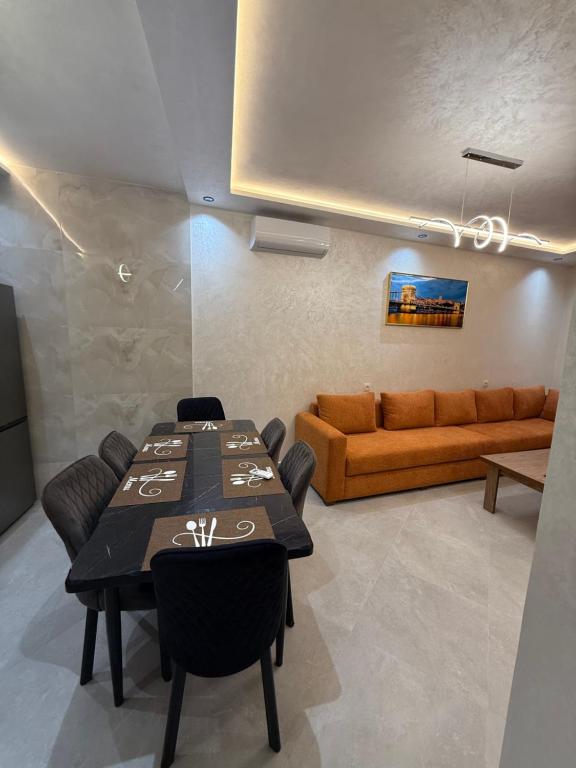 a dining room with a table and a couch at اقامة هبة 1 in Yebha