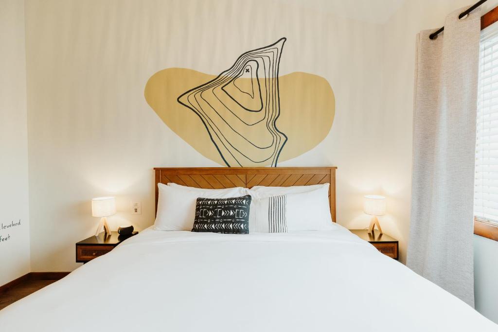 a bedroom with a white bed with a heart on the wall at Mt Cleveland at Switchback Suites Boutique Hotel in Kalispell