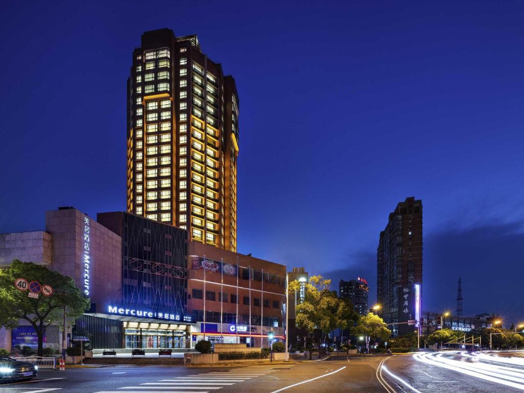 a tall building with lights on it at night at Mercure Nantong Downtown in Nantong