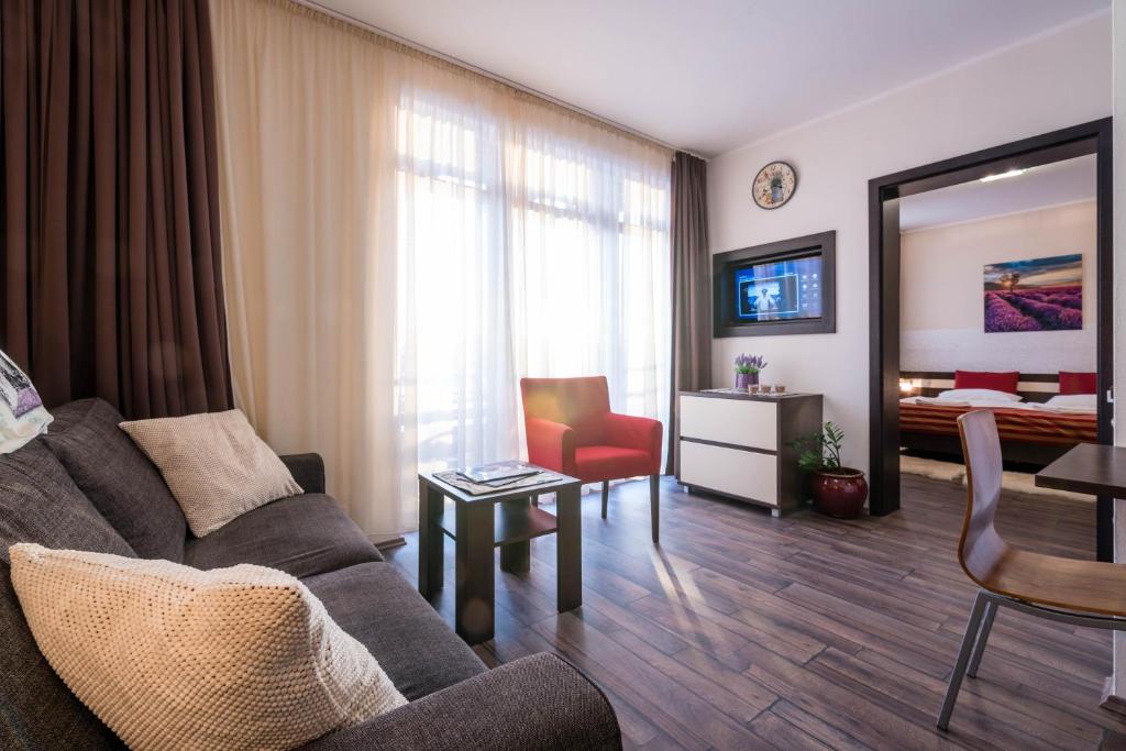 a living room with a couch and a bedroom at Apartman Mirka - Hotel Luka in Bešeňová