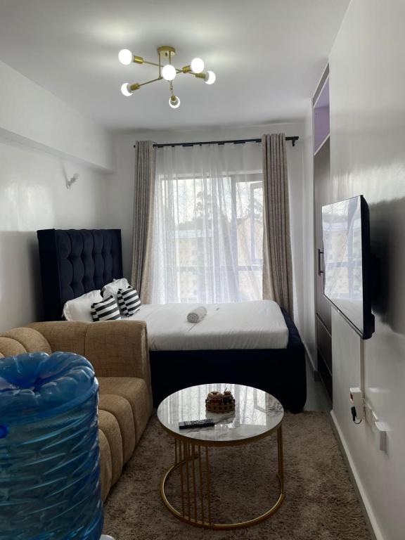 a living room with a bed and a couch at Naivasha road Studio Opposite ILRI in Nairobi