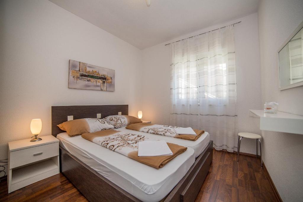een groot bed in een kamer met een raam bij Apartments Kati in Omiš