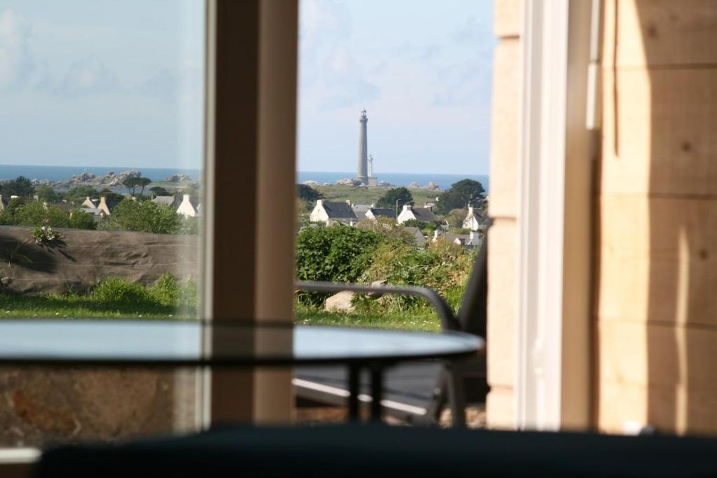 a table with a view of a city from a window at Ty glaz in Plouguerneau