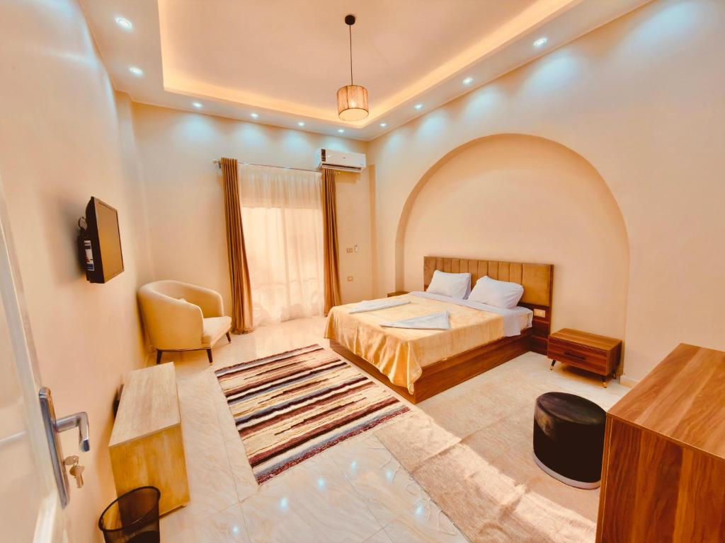 a hotel room with a bed and a desk at Djorff Palace - Private villa & swimming pool & central location in Al Aqālitah