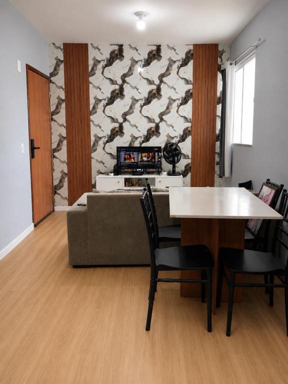 a living room with a table and a couch at Apartamento Com Piscina prox a BR in Ananindeua
