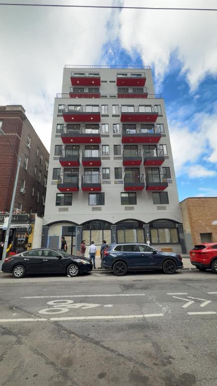 a tall building with cars parked in front of it at Skylux Hotel - Long Island City in Queens