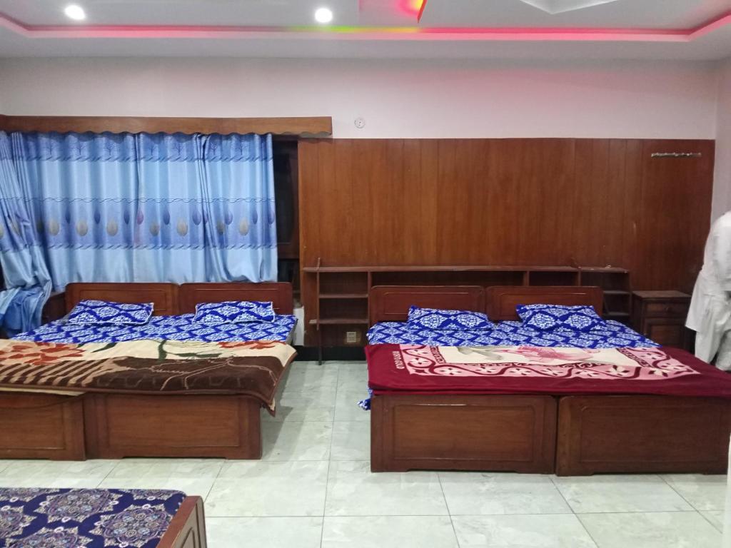 two beds sitting in a room with at Nice Guest House GPO Murree in Murree