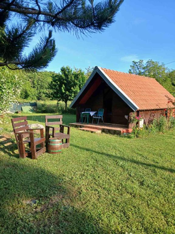 a cabin with a table and benches in the grass at Hidden Nest For Two in Herceg-Novi