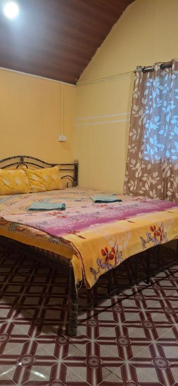 a bed sitting in a room with a window at The Green resort goa in Canacona