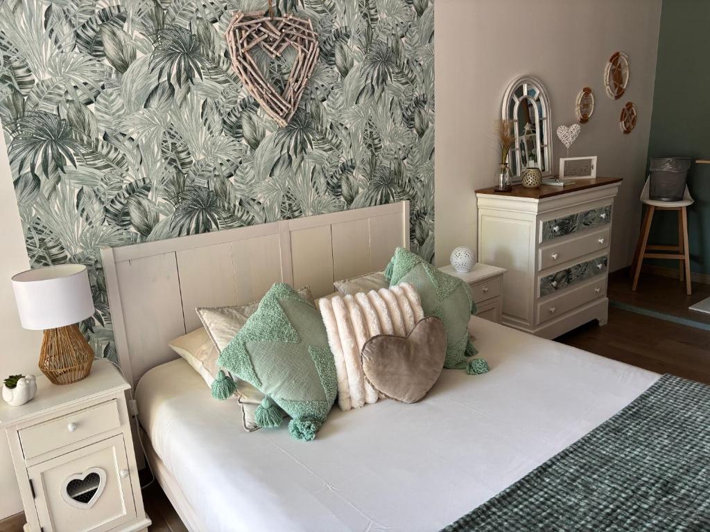 a bedroom with a bed with pillows and a wallpaper at La Carola in Bordeaux-Saint-Clair