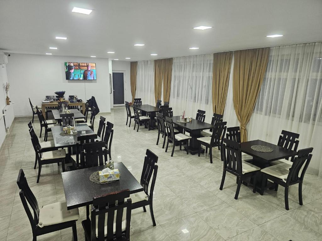 a dining room with tables and chairs in a restaurant at Pensiunea Casa Bianca-Târgu Jiu in Târgu Jiu
