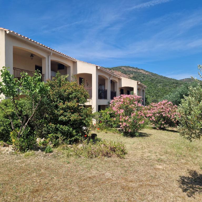 a house with flowering bushes in front of it at I Mucchi in Galeria
