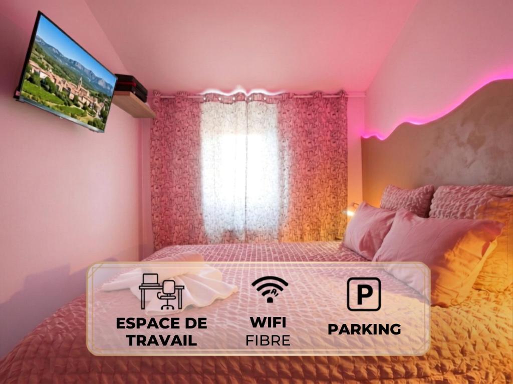 a pink bedroom with a bed with a sign on it at Studio La Vague - Idéal Couple en Escapade Provence Hors Foules - Marché Samedi à Pied - Bois de la Lare 6km - CENTRE VILLE Auriol - Marseille 27km - Aubagne 11km - WIFI HD - Climatisation in Auriol