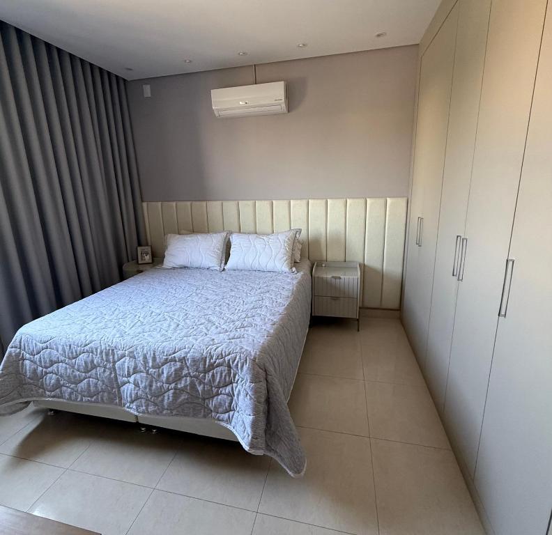 a small bedroom with a bed and a cabinet at Apartamento 2 quartos com ar-condicionado, Wi-Fi e Netflix in Americana