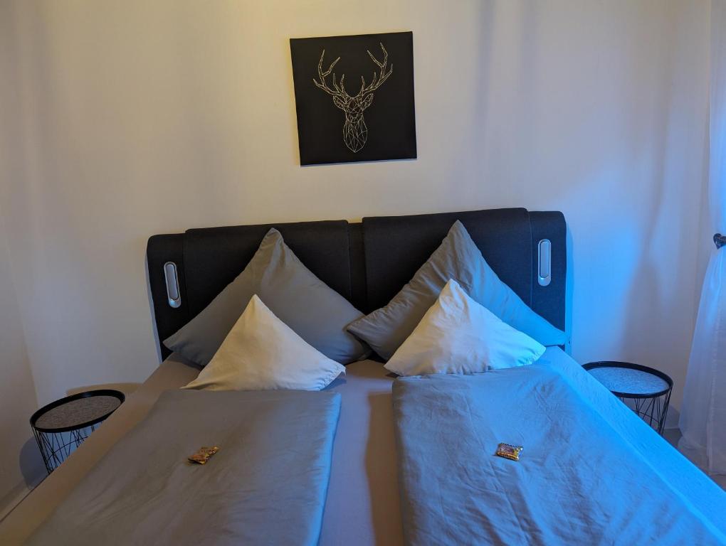 un letto con lenzuola blu e cuscini bianchi di Ferienwohnung Eifelglück a Utzerath