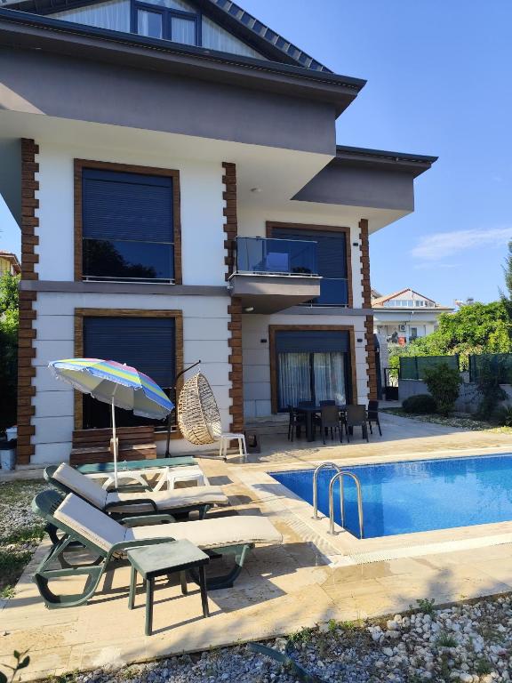 a villa with a swimming pool and a house at canyon villa in Kemer