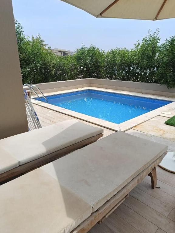 a swimming pool on a deck with a chair and a table at Luxury Rotana Villa in Salalah