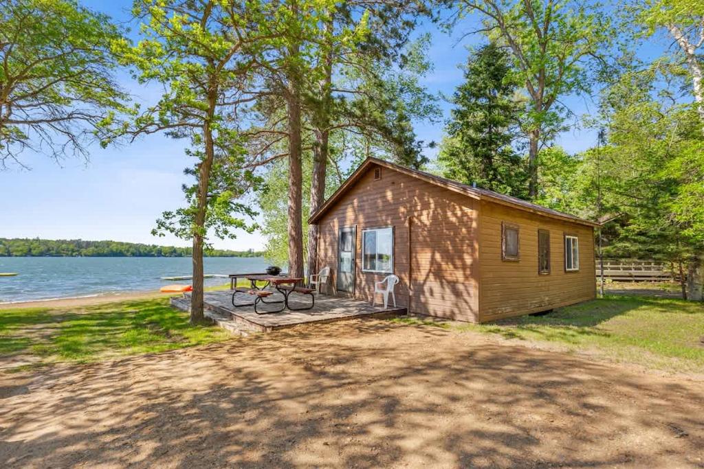 a tiny house on the shore of a lake at Cabin #9 2BR 1BA Timberlane Resort in Park Rapids