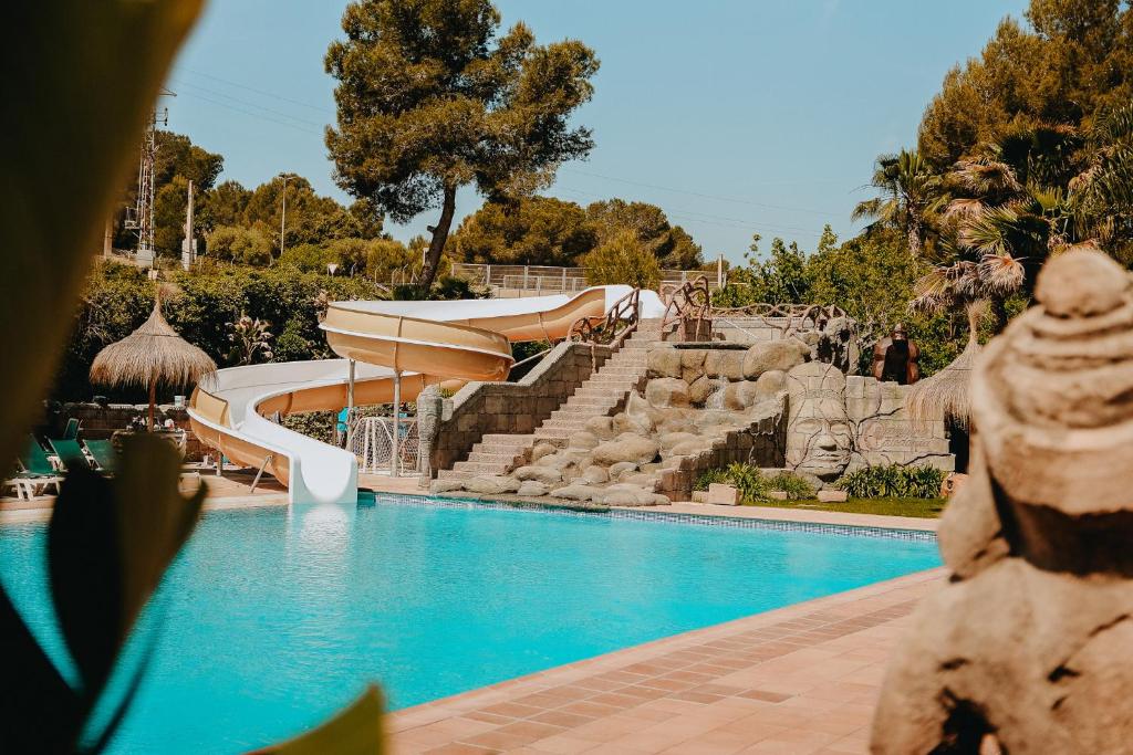 a resort with a swimming pool with a slide at Camping Caledonia in Tamarit