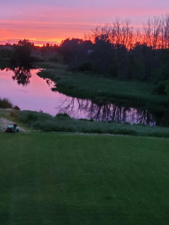a view of a river with a sunset in the background at A River Runs Through It in Napanee