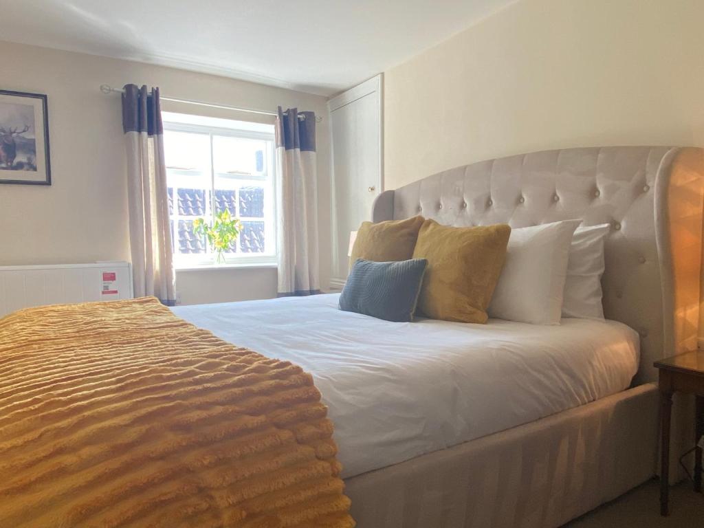 a bedroom with a large white bed with a window at Spa View Apartments in Ripon