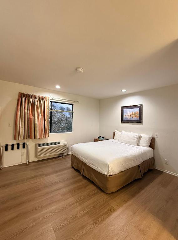 a bedroom with a large bed and a window at Jolly Roger Hotel in Los Angeles