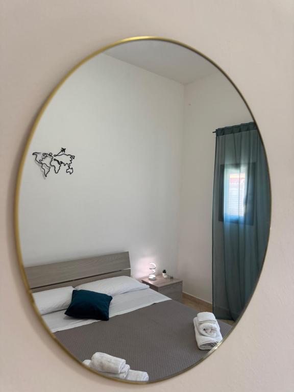 a mirror reflecting a bed in a bedroom at Sicilia Bedda Holiday Home in Cinisi