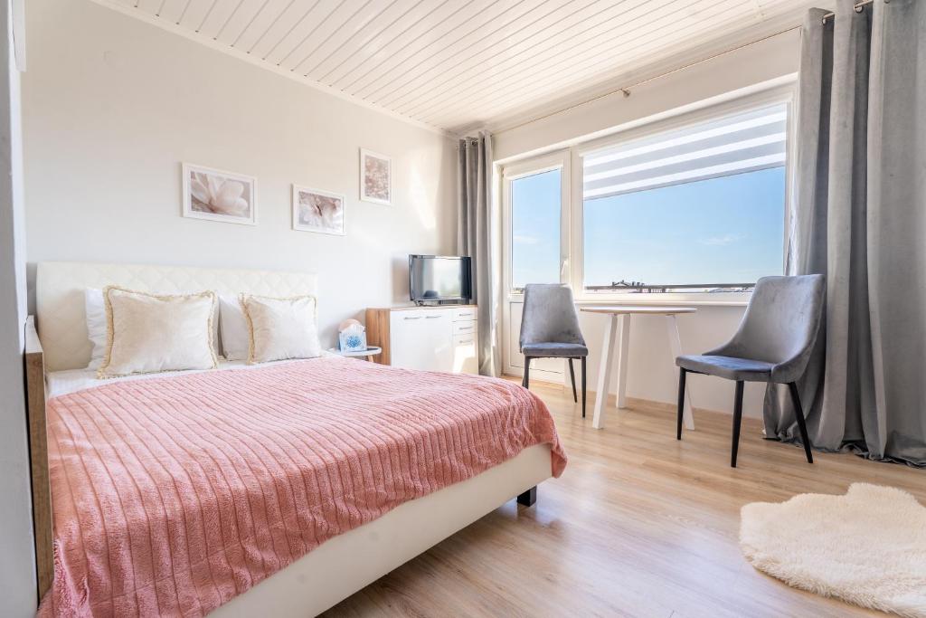 a bedroom with a bed and a desk and a window at Magdalena in Karwia