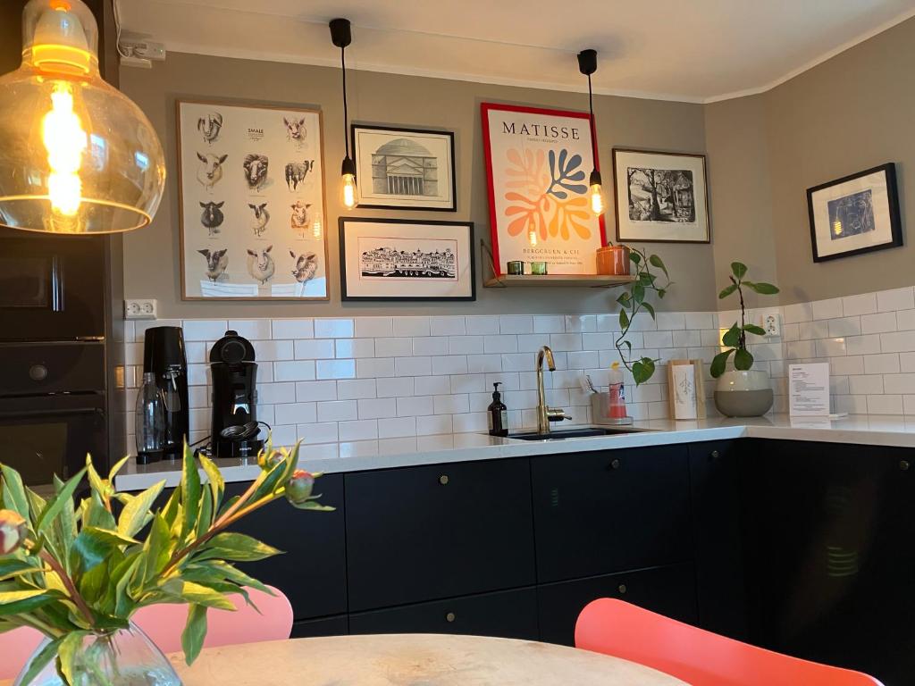 a kitchen with a table and some pictures on the wall at Bright and central apartment in Stavanger