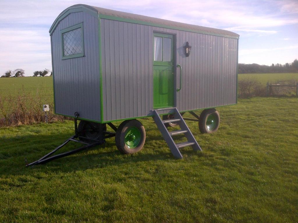 a tiny house on a stand in a field at Shrublands Farm Shepherd's Hut in Sidestrand