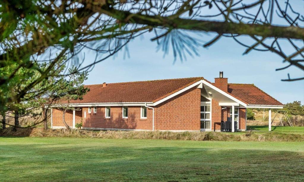 a red brick house with a green yard at VE087-Vejers-Strand-Jafdalvej-41 in Vejers Strand