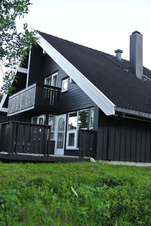 une maison noire avec une terrasse couverte et une terrasse dans l'établissement Trysil Alpin 16A Top location, à Trysil