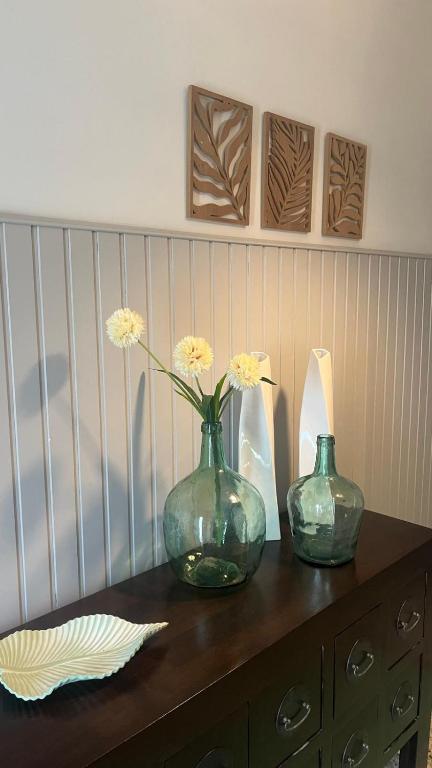 two vases sitting on a dresser with flowers in them at Casa Viñao in Boborás