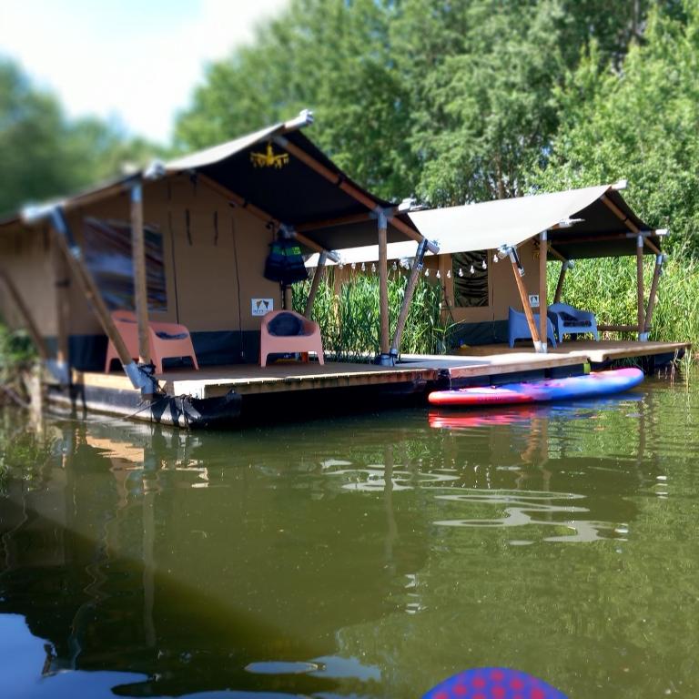 a house on a dock on a body of water at Safaritent 3 in Biddinghuizen