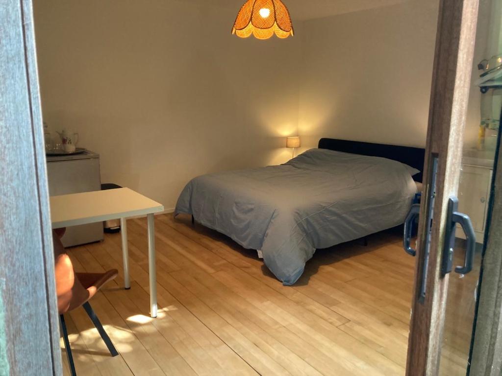 a small bedroom with a bed and a table at Room in a garden Late CHECKOUT in Ghent