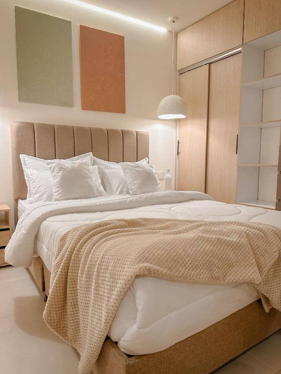 a bedroom with a large bed with white pillows at CityZen Apartahotel in Florencia