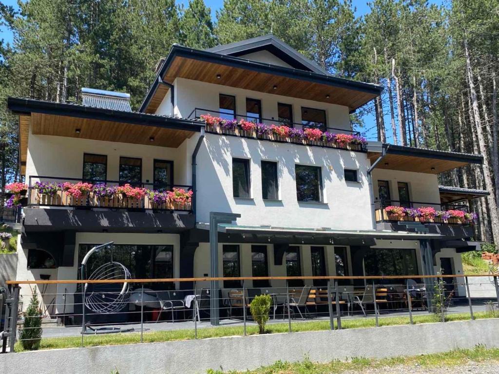 a white building with flower boxes on the balconies at Vila Aspen - Mountain View Apartments in Delčevo
