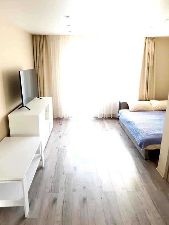 a bedroom with a bed and a white dresser at Ezerkrasts Daugavas 7 in Liepāja