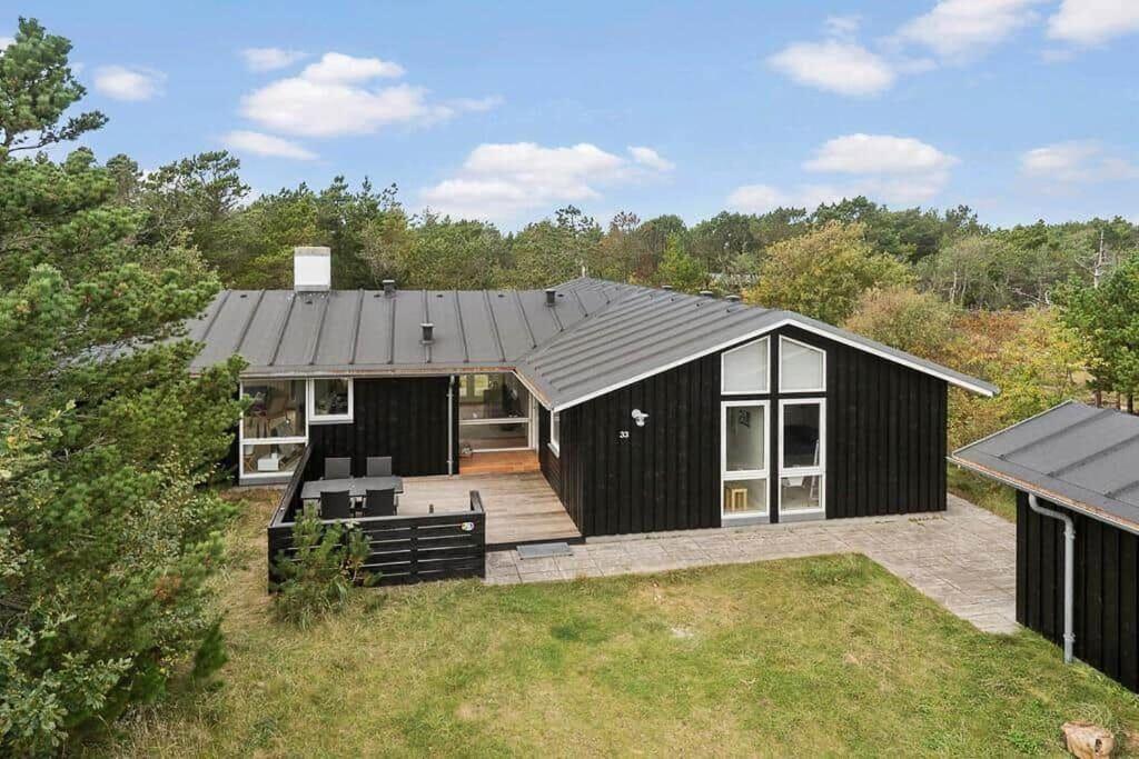 a black house with a roof on a yard at 1077-Thisted-Johns-Vej-33 in Klitmøller